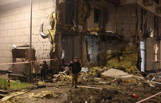 Hombres en el lugar de un edificio de apartamentos que fue alcanzado durante un ataque ruso con misiles y drones en Kiev, en medio del ataque de Rusia a Ucrania.